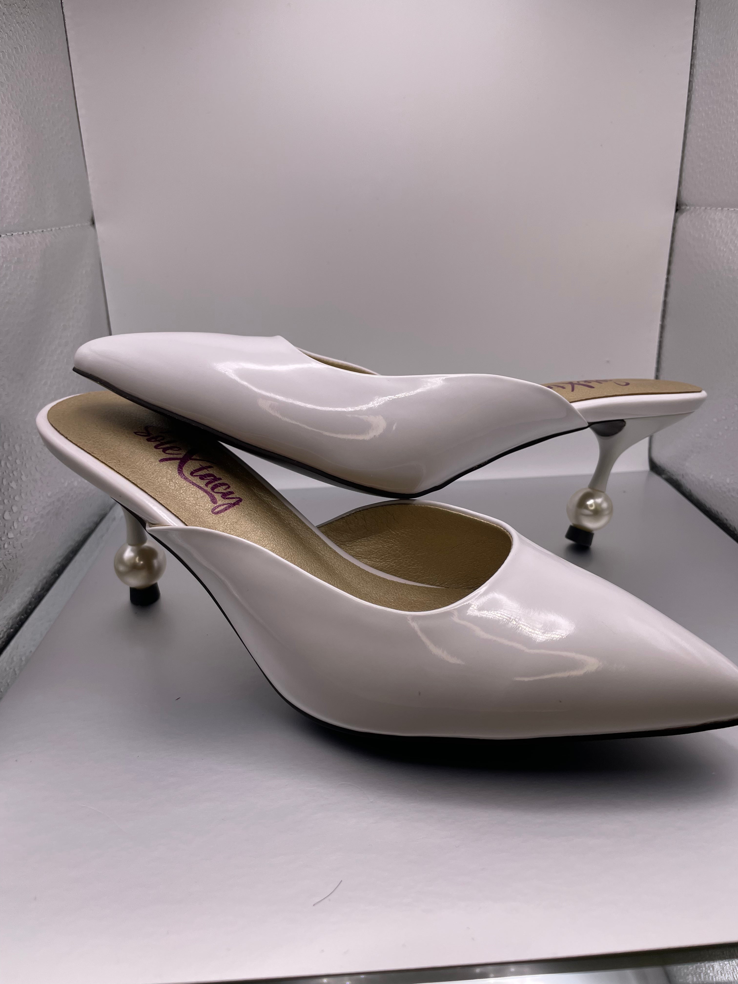 White pointed-toe mule heels with mid block heel and gold accents