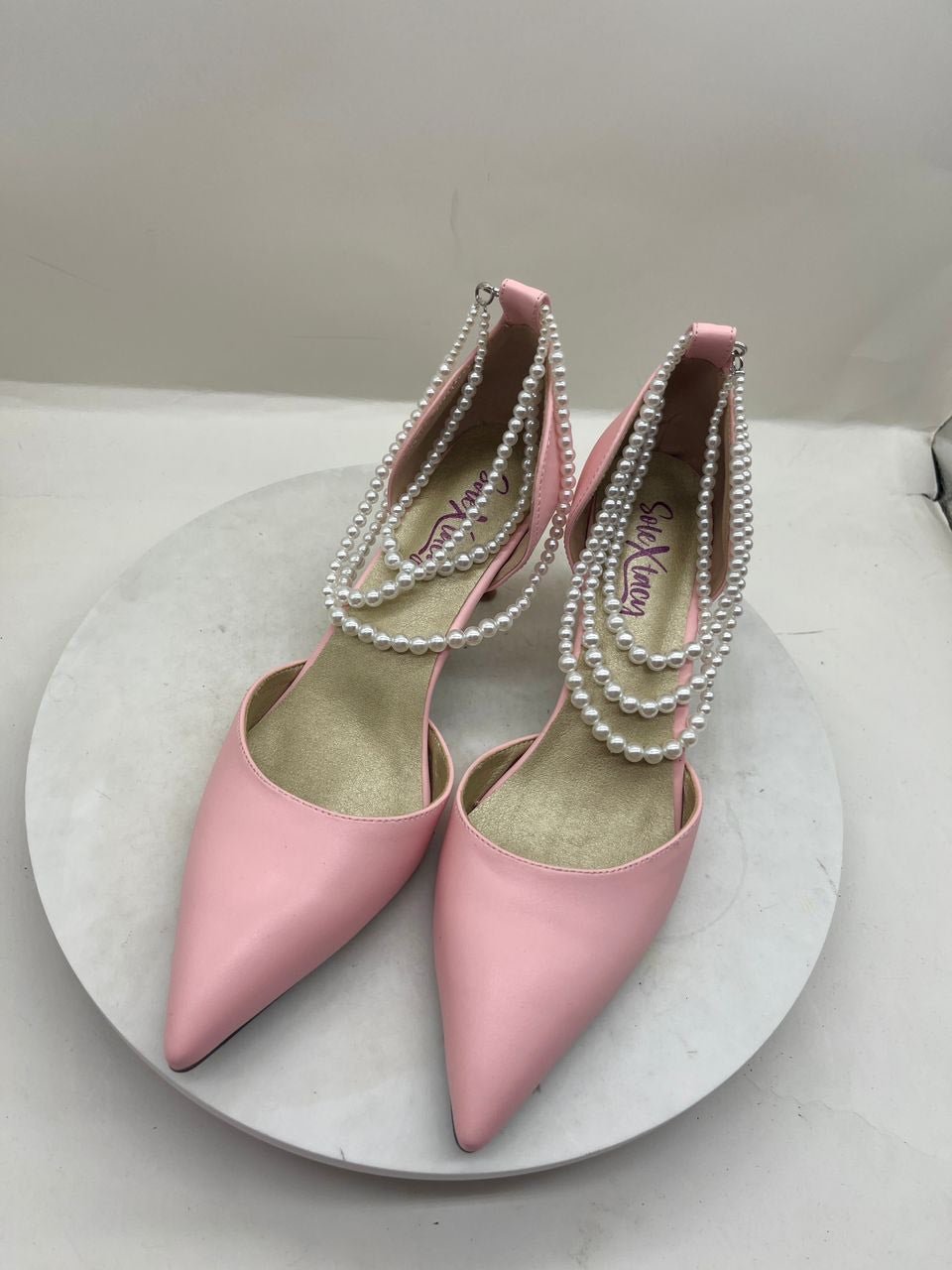 Pink pointed-toe stiletto pumps with pearl chain trim and double sling straps
