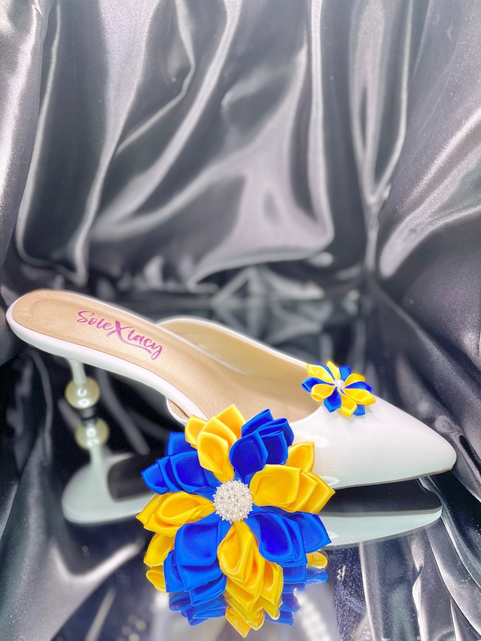 White flats with blue and yellow Kanzashi flower clusters on the toe