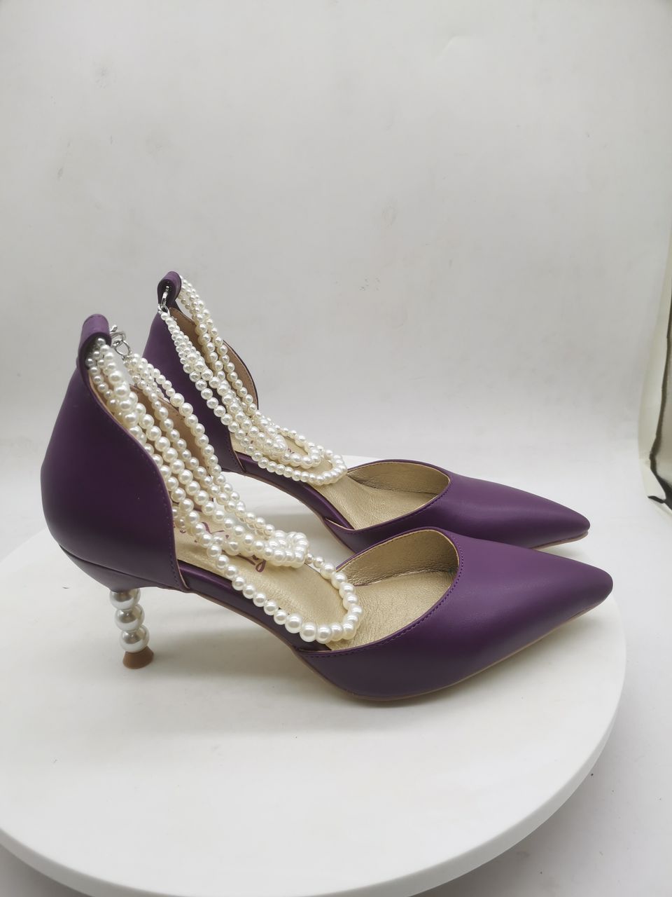 Purple heeled slingback shoes with long white pearl-bead ankle straps