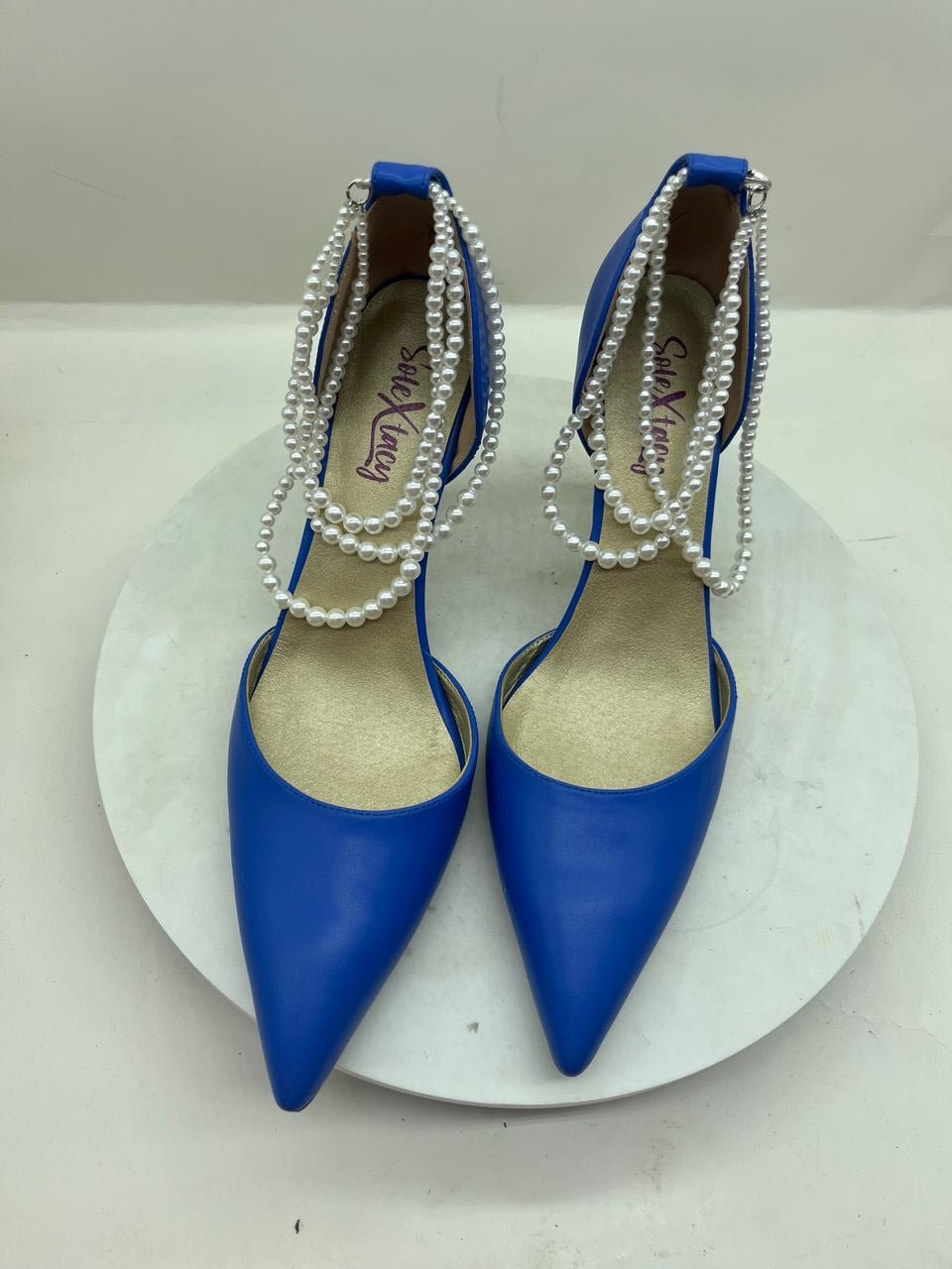 Blue pointed-toe stiletto pumps with pearl chain trim and double sling straps